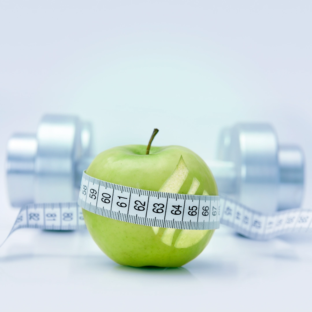 Green apple with  measuring tape around it ot highlight the importance of healthy eating in addition to our injection based weight loss program